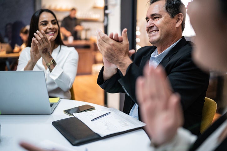 Mature businessman celebrating with his coworkers on a meeting at office